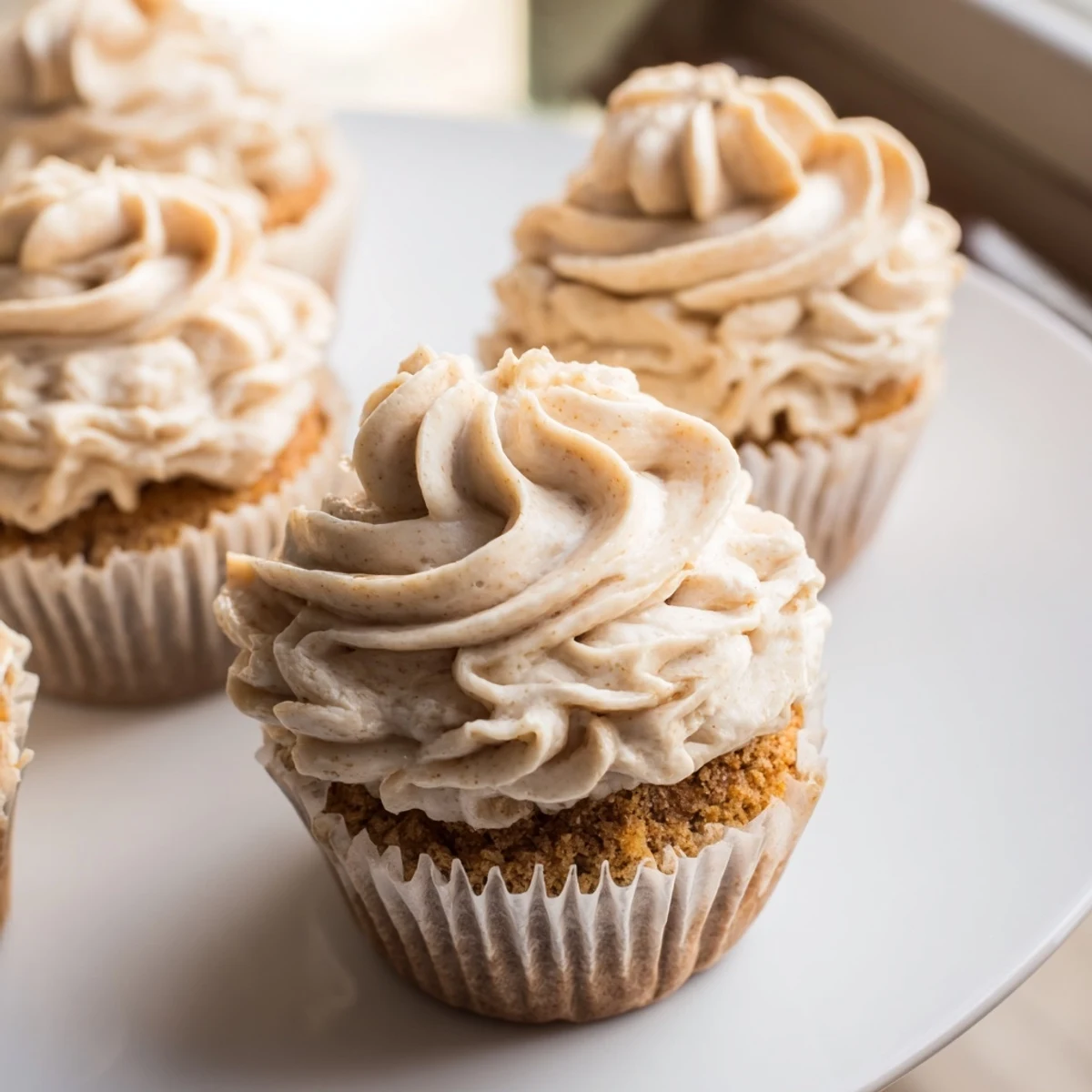 Close-up of golden vanilla cupcakes with a generous swirl of sweet vanilla buttercream, ready to eat.