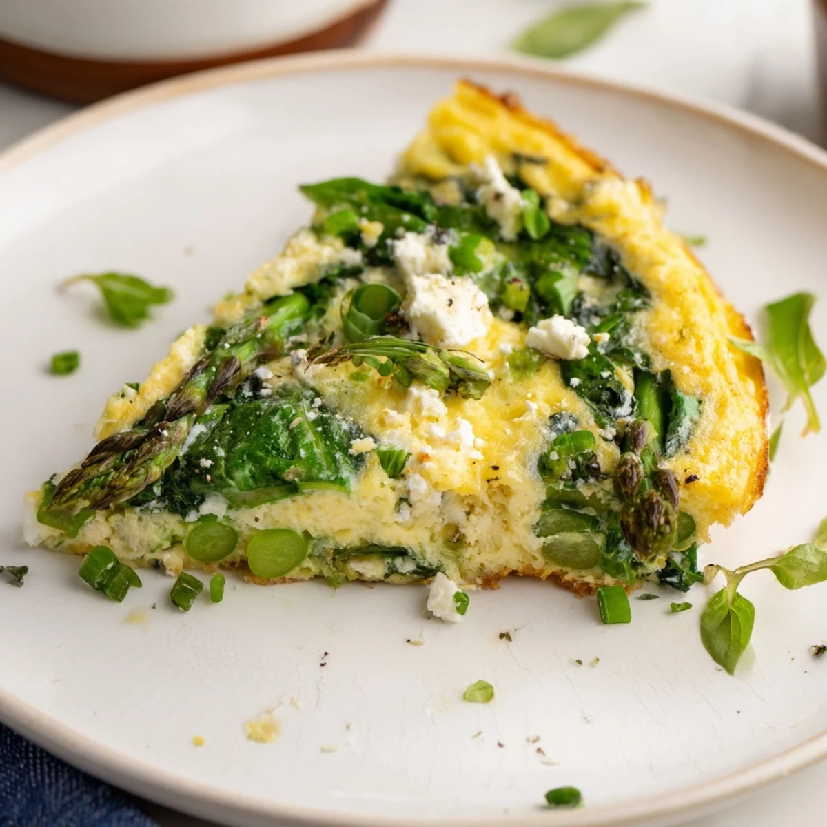 Golden brown Meadow-Soft Cozy Plate: Frittata with vibrant spring greens and creamy goat cheese.