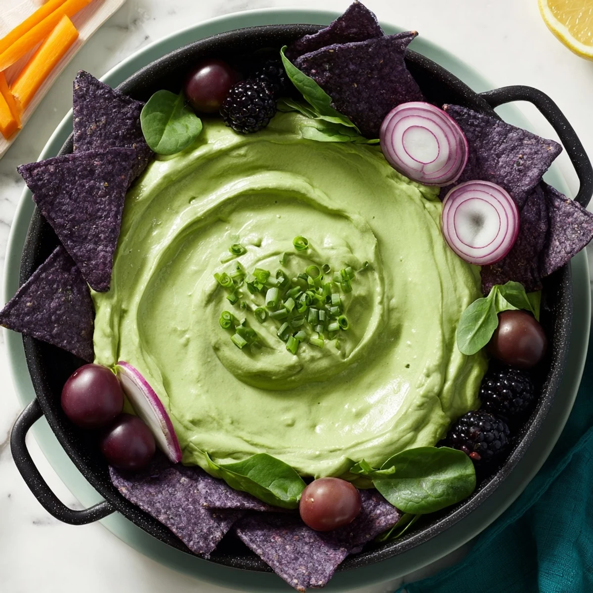 A creamy Witch's Brew Cauldron, made with avocado, perfectly served as an appetizer with dipping goodies.