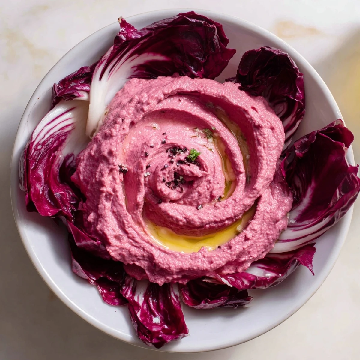 Vibrant The Velvet Rose appetizer, beet hummus swirled beautifully into rose shapes on a plate.