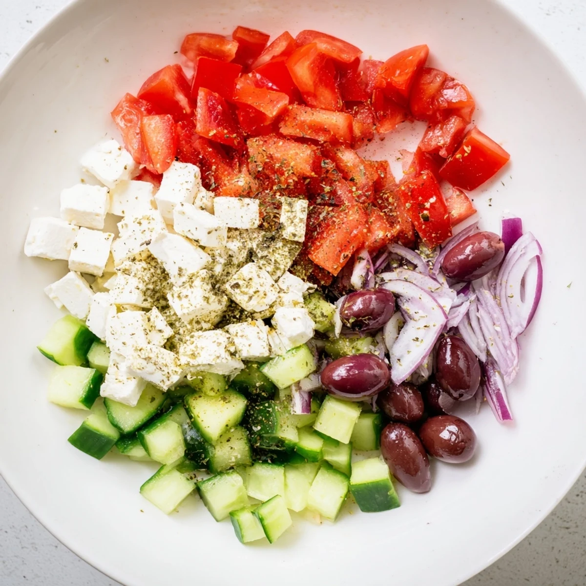 Mediterranean Salad with glistening tomatoes, cucumbers, and a creamy feta cheese topping.