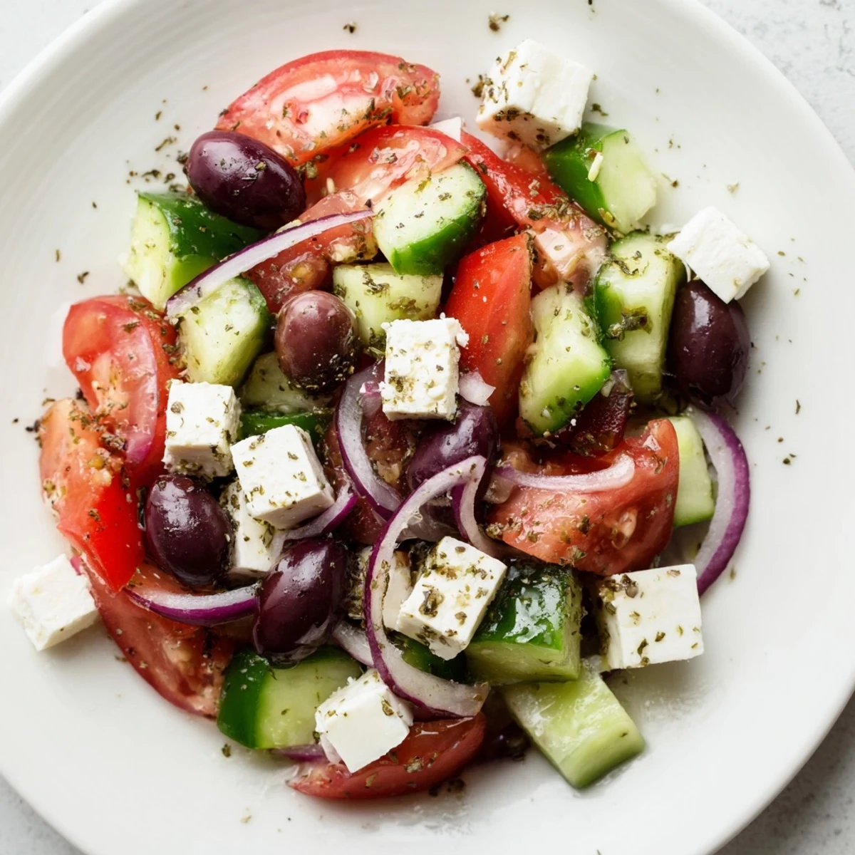 A close-up of a colorful Mediterranean Salad, ready to be tossed with olive oil dressing.