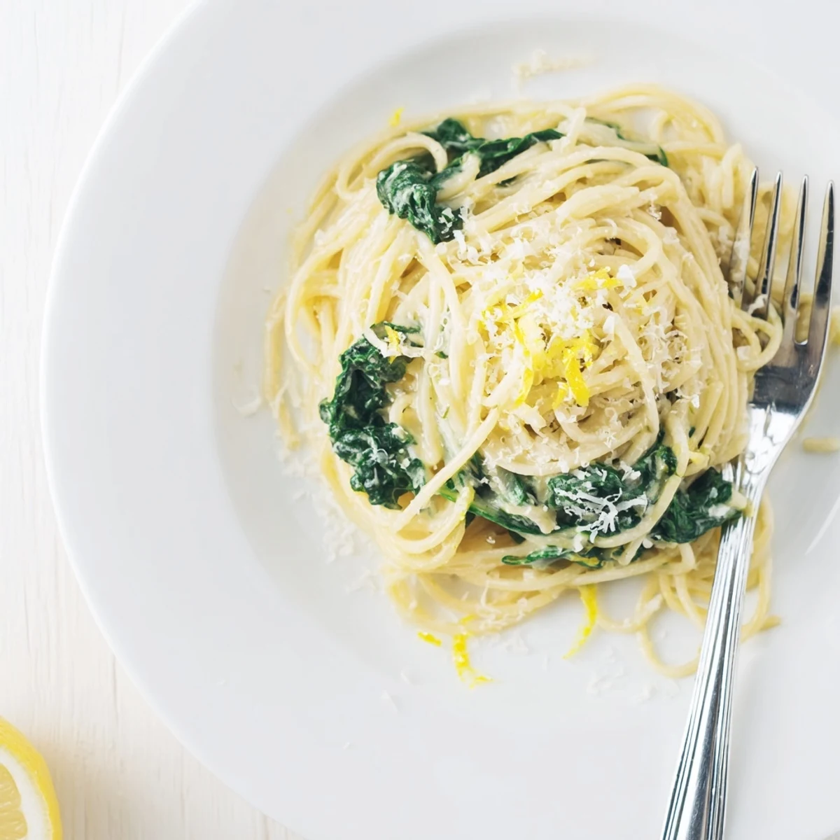 Creamy Lemon Spinach Spaghetti twirled in a silky lemon cream sauce with tender spinach leaves and fresh Parmesan garnish.