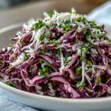 A close-up of tangy Red Cabbage Coleslaw with Apple and Parmesan on a serving platter.