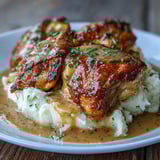 Shredded Slow Cooker Honey Mustard Chicken piled onto a fluffy biscuit, garnished with fresh parsley and a drizzle.