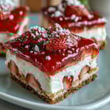 Strawberry Lemonade Bars with Shortbread Crust: bright pink bars with a buttery golden base, topped with a tangy lemon-strawberry filling, dusted lightly with powdered sugar for a refreshing summer dessert.