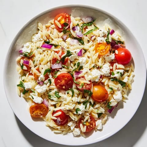 Fresh Tomato Feta Orzo tossed with herbs, a simple, delicious Mediterranean side dish.