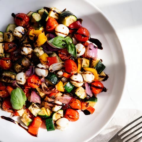 Colorful Roasted Veggie Caprese Salad featuring warm roasted tomatoes and bell peppers drizzled with sweet balsamic glaze.