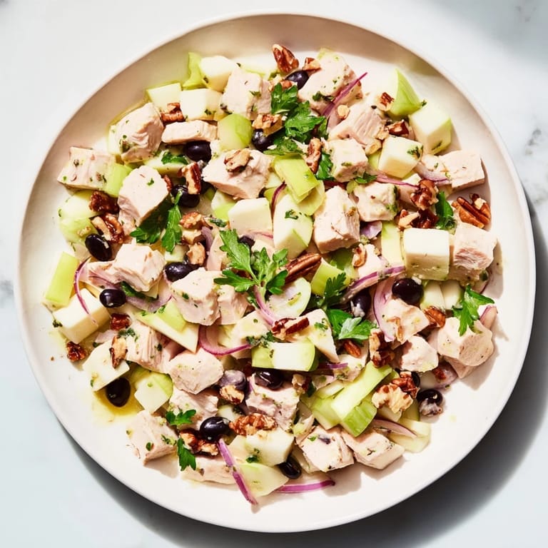 A colorful bowl of Chicken and Apple New Years Luck Salad, garnished with pecans, promises a delicious meal.