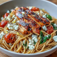 High protein pasta bowl with grilled chicken, creamy cottage cheese, and fresh spinach in a savory herb sauce.